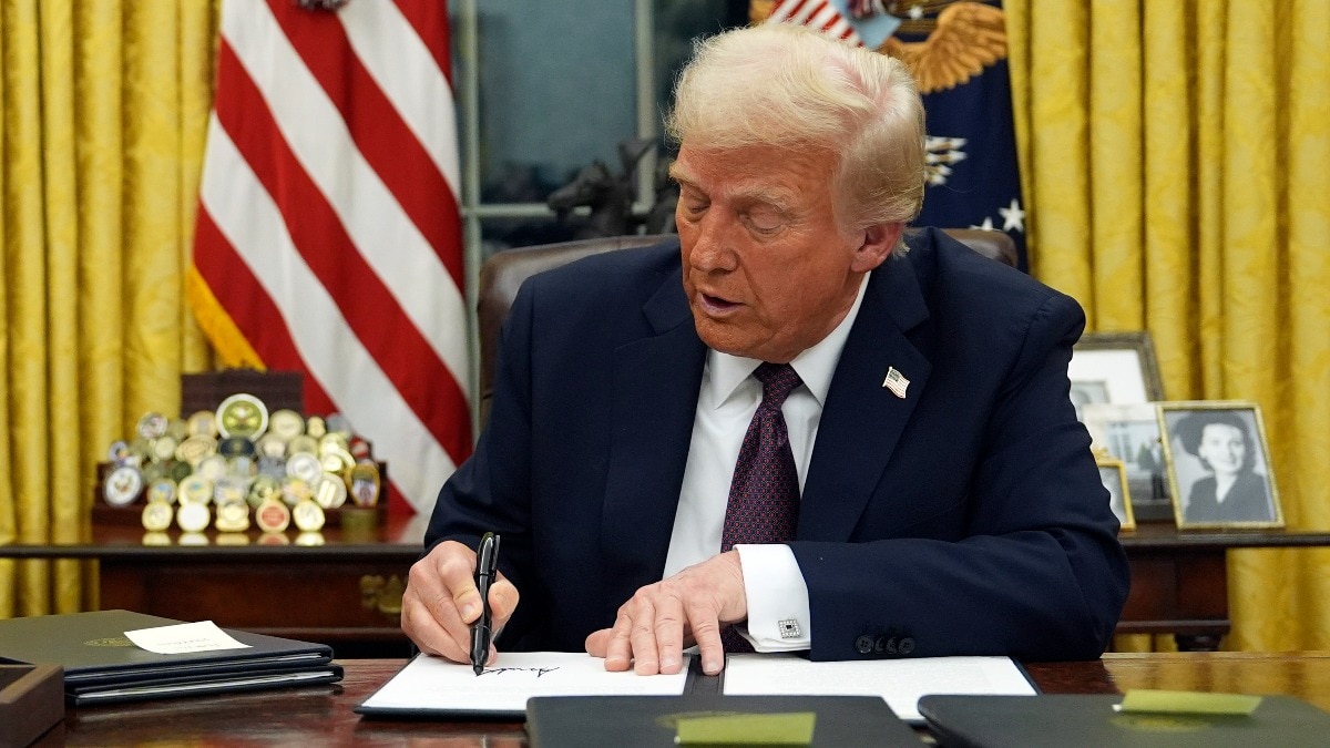 President Donald Trump signs an executive order in the Oval Office of the White House