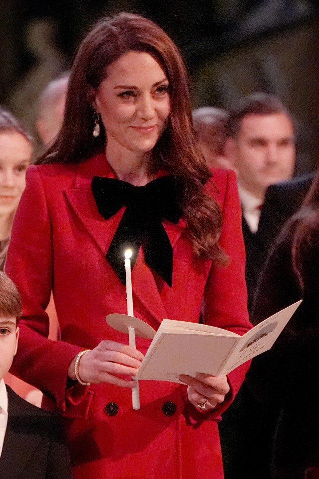 The Princess of Wales holding a lit candle and a program at a Christmas carol service.