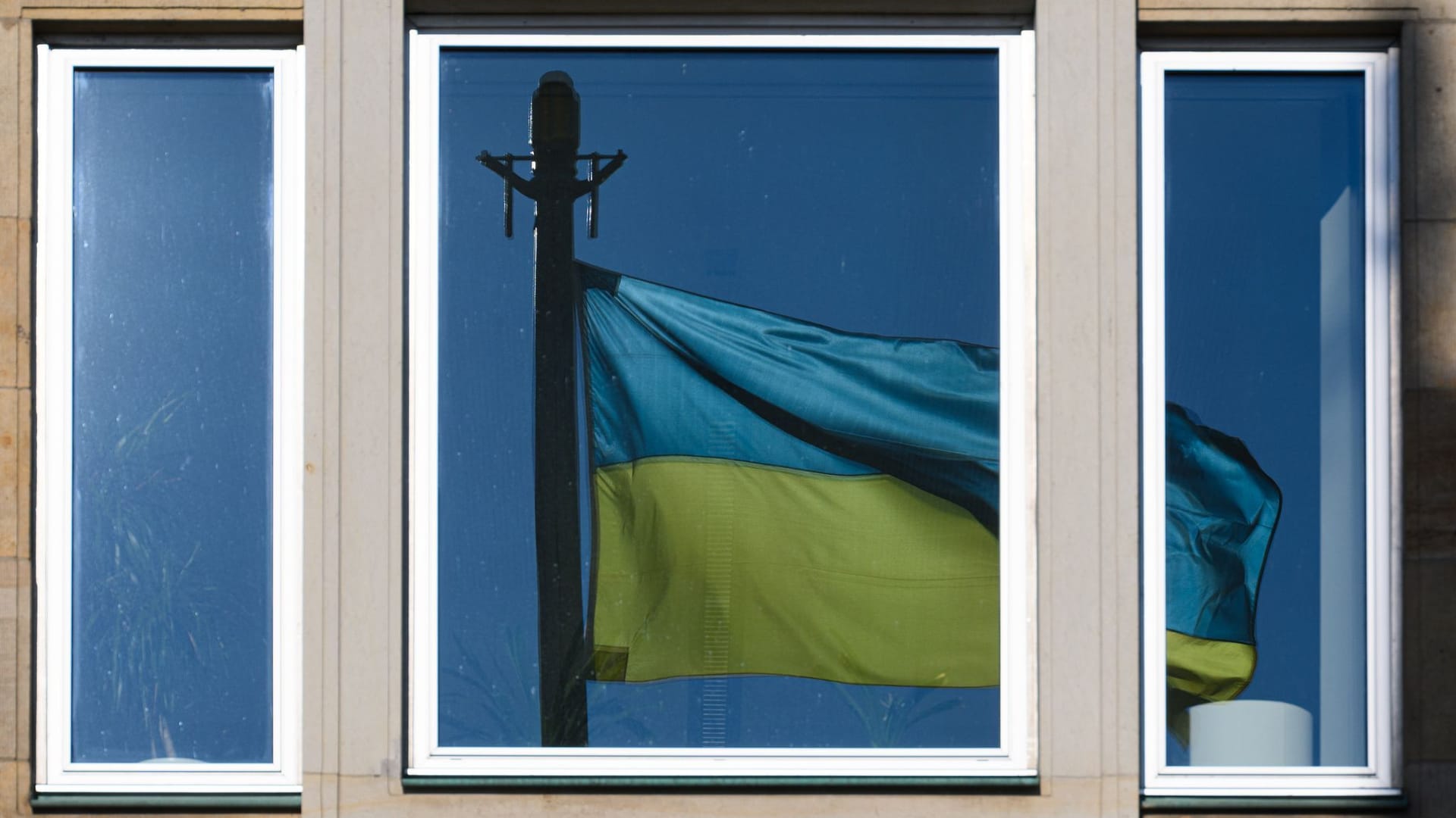 Eine Fahne der Ukraine spiegelt sich in einem Fenster Eine Fahne der Ukraine spiegelt sich in einem Fenster