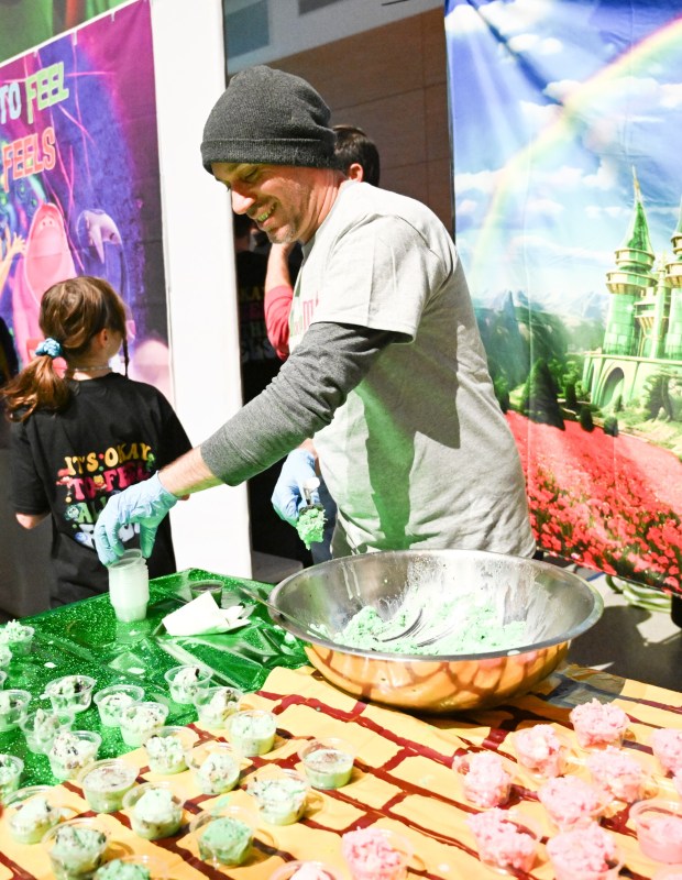 Dustin Schoof serves ice cream at the WFMZ booth Saturday, Jan. 4, 2025, during Ice Cream Wars at Da Vinci Science Center in Allentown. The annual event features Lehigh Valley businesses creating unique flavors of ice cream, with attendees casting votes to determine the champion. (Amy Shortell/The Morning Call)