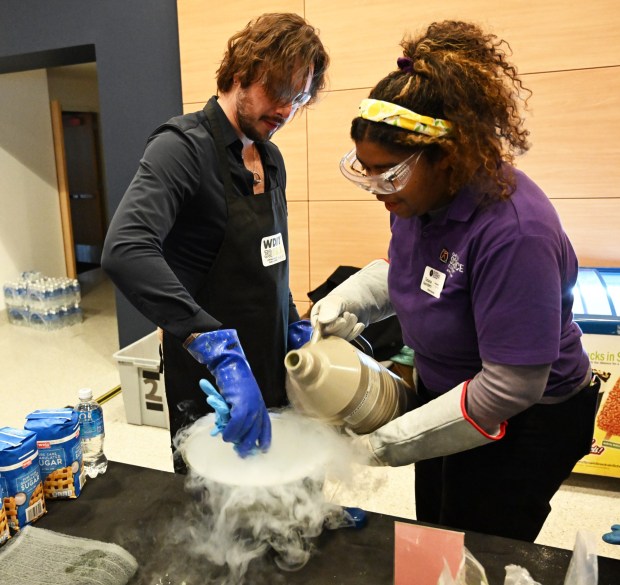 Louis Holzman, of Team WDIY, stirs while the Da Vinci Science Center's Tatiana Saunders pours liquid nitrogen into the bowl to create ice cream Saturday, Jan. 4, 2025, during Ice Cream Wars at Da Vinci Science Center in Allentown. The annual event features Lehigh Valley businesses creating unique flavors of ice cream, with attendees casting votes to determine the champion. (Amy Shortell/The Morning Call) need a name in this one