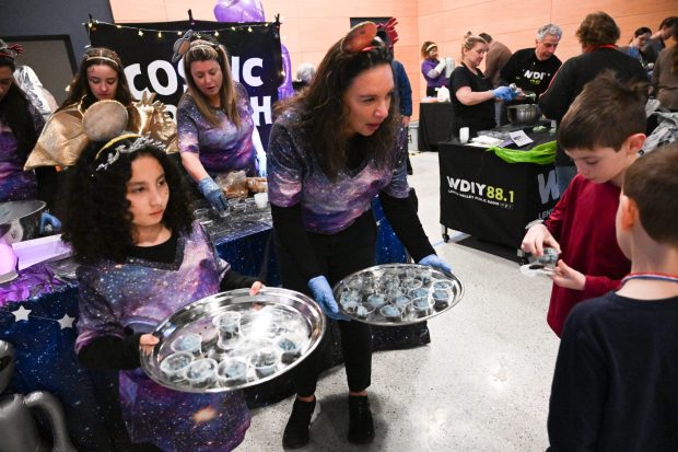 Isabella Rundy, 10, serves ice cream alongside Melinda Stumpf at the PPL Booth on Saturday, Jan. 4, 2025, during Ice Cream Wars at Da Vinci Science Center in Allentown. The annual event features Lehigh Valley businesses creating unique flavors of ice cream, with attendees casting votes to determine the champion. (Amy Shortell/The Morning Call)