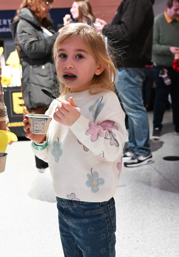 Madelyn Rosborough, 4, has a ring of blue ice cream around her mouth as she licks every bit from her bowl Saturday, Jan. 4, 2025, during Ice Cream Wars at Da Vinci Science Center in Allentown. The annual event features Lehigh Valley businesses creating unique flavors of ice cream, with attendees casting votes to determine the champion. (Amy Shortell/The Morning Call)