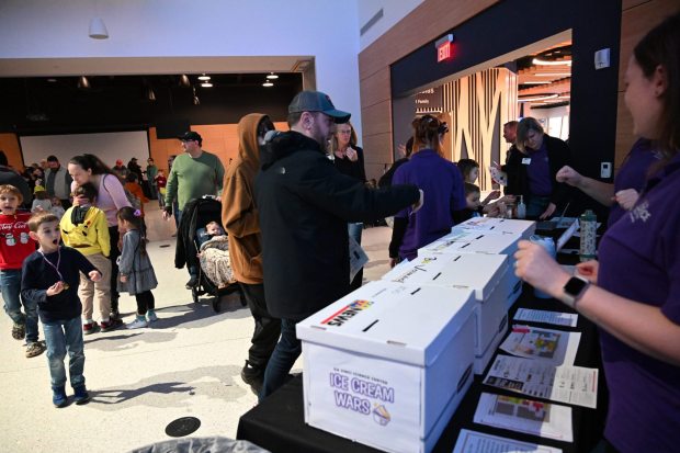 People vote for their favorite team Saturday, Jan. 4, 2025, during Ice Cream Wars at Da Vinci Science Center in Allentown. The annual event features Lehigh Valley businesses creating unique flavors of ice cream, with attendees casting votes to determine the champion. (Amy Shortell/The Morning Call)