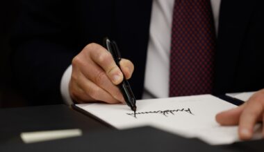 Close-up of hand holding a sharpie and signing a piece of paper