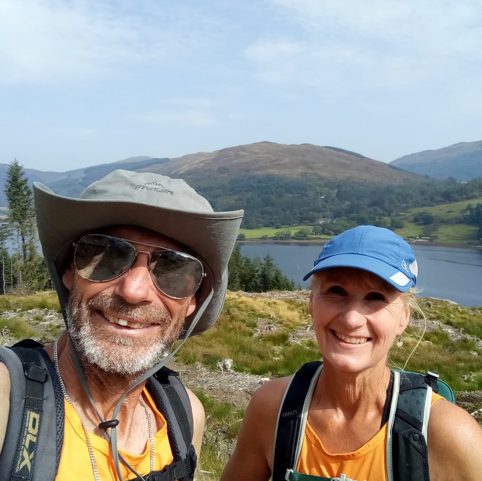 outdoor selfie of two people on a hiking trail by a lake