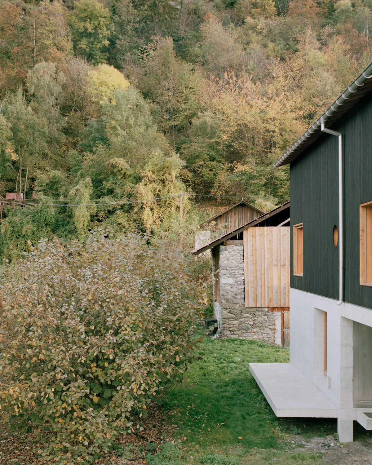 lionel ballmer architectes' charred wood house echoes traditional barns of rural switzerland