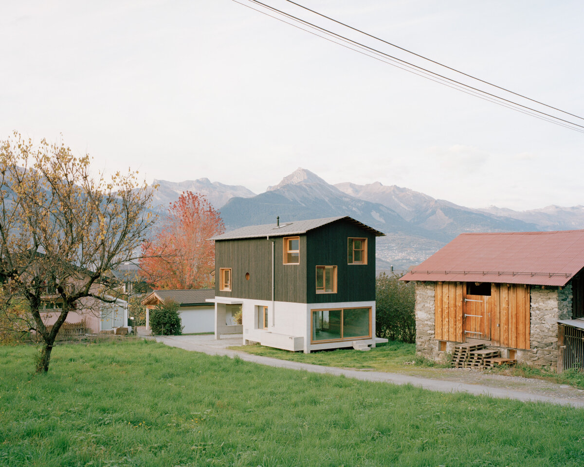 lionel ballmer architectes' charred wood house echoes traditional barns of rural switzerland