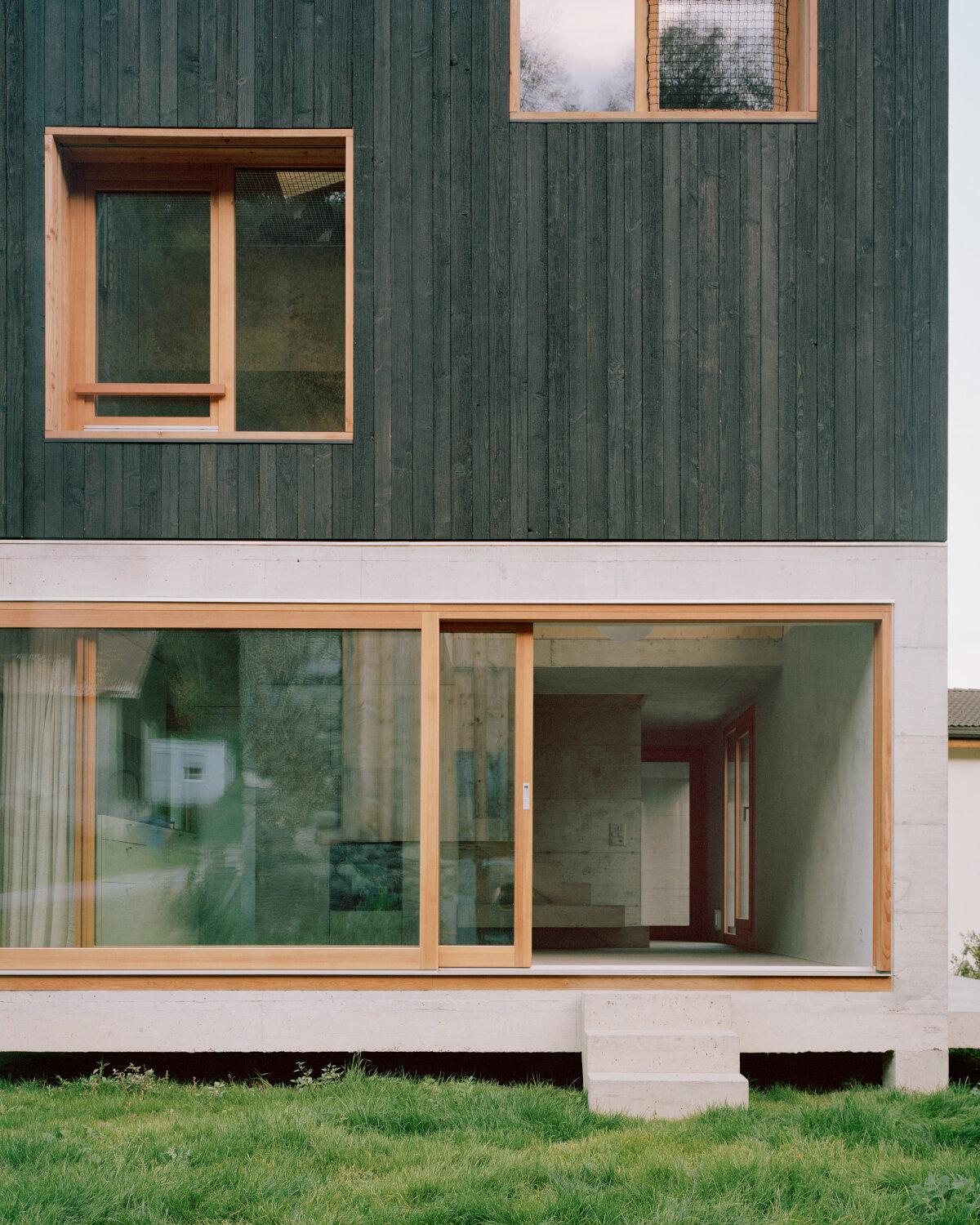lionel ballmer architectes' charred wood house echoes traditional barns of rural switzerland