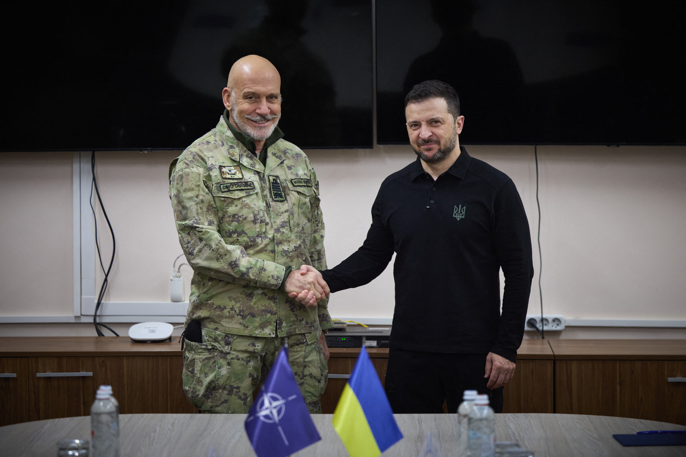Volodymyr Zelensky and Giuseppe Cavo Dragone shaking hands.