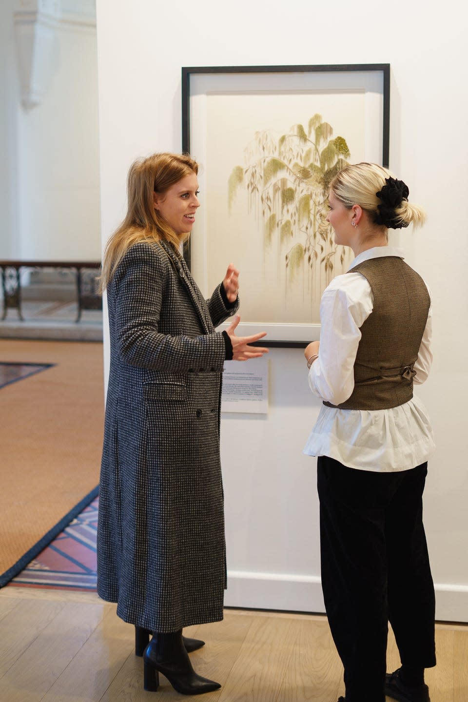 Two individuals discussing an artwork in a gallery setting