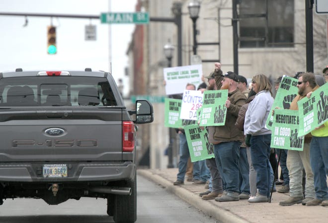 American Federation of State, County and Municipal Employees members picket downtown Monday afternoon.