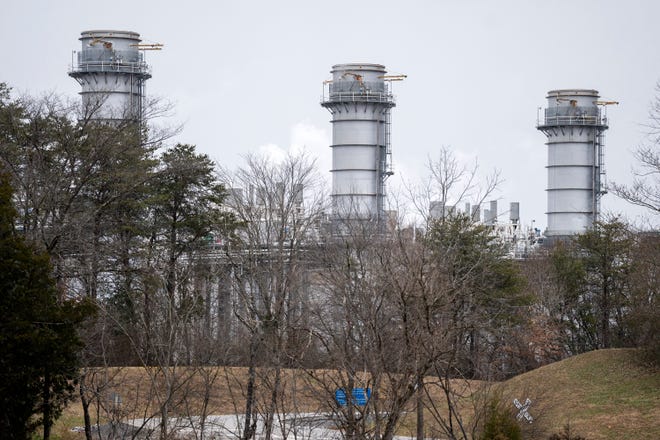 Flue gas stacks at TVA's John Sevier Combined Cycle Plant in Rogersville, Tenn., rise from the surrounding landscape. The utility is investing billions in more plants like it to meet demand.