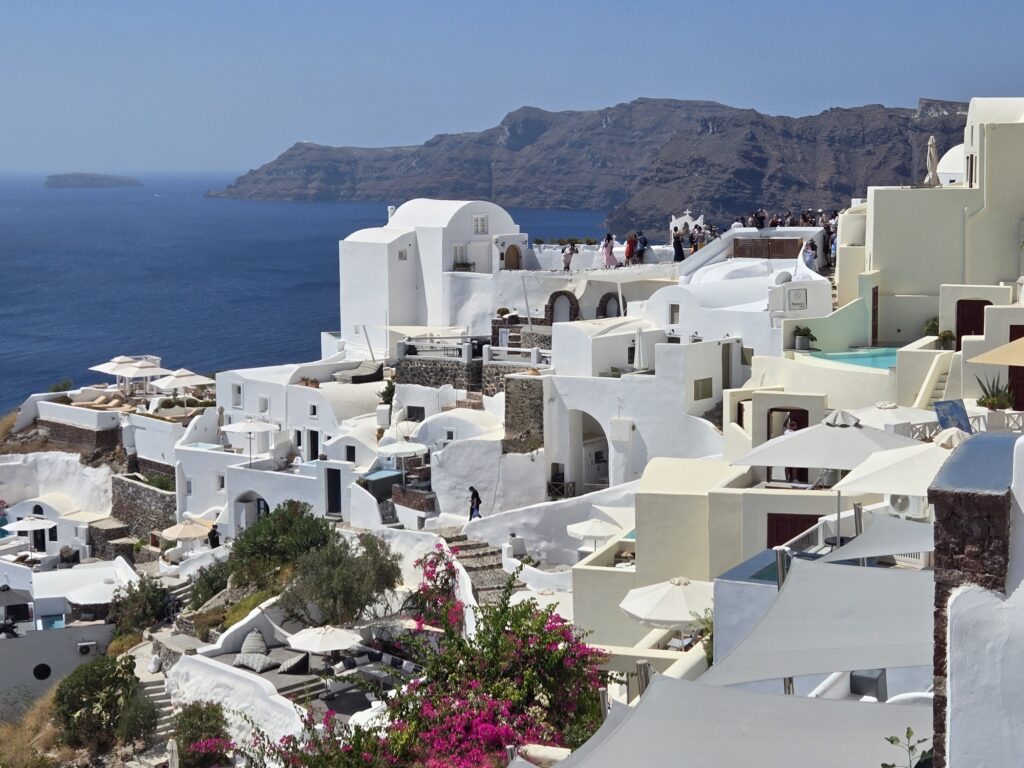 Santorini's volcanic cliffs are topped by white washed structures set against a brilliant blue sea. Image: Weatherboy