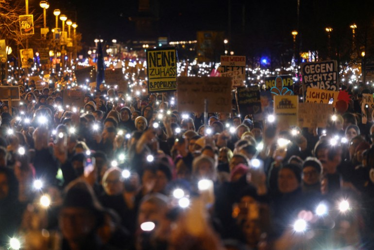 People light up their mobile phones during a protest against the migration plans of the CDU party leader and top candidate for Chancellor Friedrich Merz and the far-right Alternative for Germany party (AfD), in Berlin, Germany 