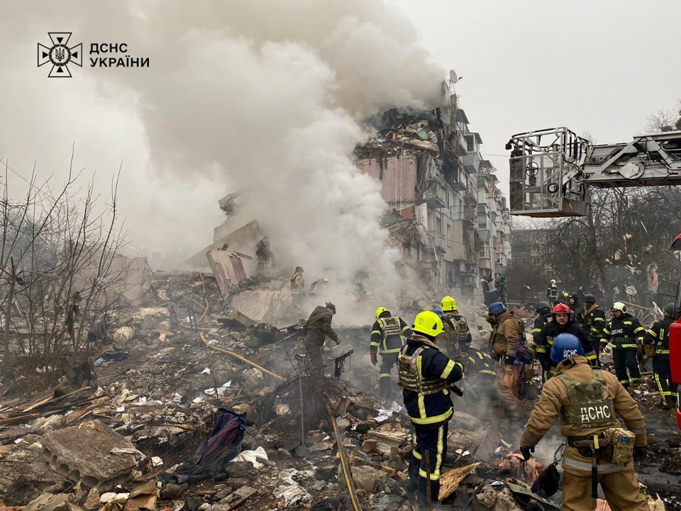 Ukrainian rescuers at the site of a rocket strike on a residential building.