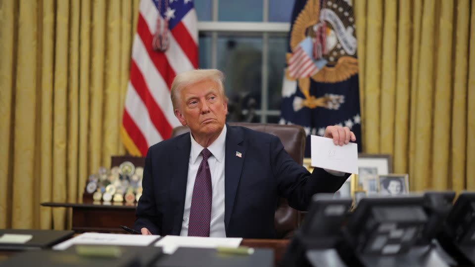 U.S. President Donald Trump holds former United States President Joe Biden's letter on the day he signs executive orders for January 6 defendants in the Oval Office at the White House on Inauguration Day in Washington, U.S., January 20, 2025. REUTERS/Carlos Barria - Carlos Barria/Reuters