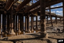 Calcified salt formations are pictured at the base of the pillars holding a disabled pumping station near Kibbutz Ein Gedi in eastern Israel on December 30, 2024. The station stopped operations due to the lake's drying. (Photo by Menahem Kahana / AFP)