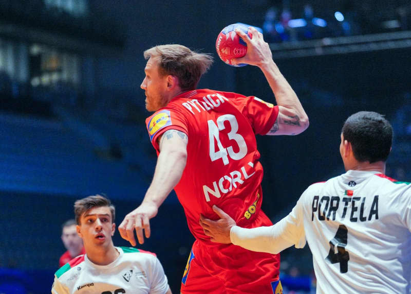 Denmark's Simon Pytlick (C) plays against Portugal's Francisco Costa (L) and Pedro Portela (R) during the IHF World Men's Championship final round, semi-final handball match between Denmark and Portugal at Unity Arena. Soeren Stache/dpa