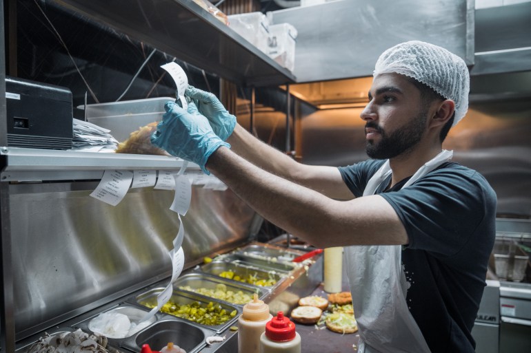 an employee checks tickets at the pass in Fries Lab