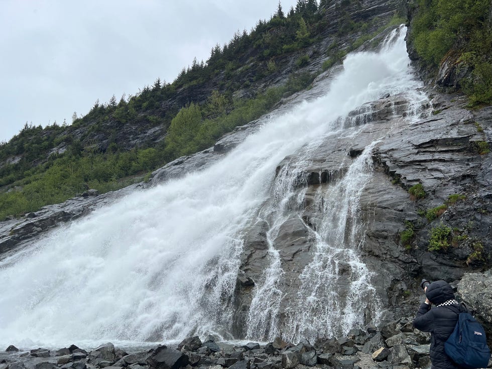 A visitor snaps a photo of Nugget Falls near Mendenhall Glacier in Juneau.