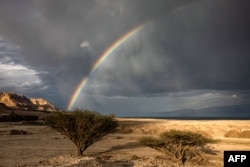 A rainbow is pictured above the Dead Sea near near Kibbutz Ein Gedi in eastern Israel on December 30, 2024. The Dead Sea, nestled where Israeli, Jordanian and Palestinian territory meet, has famously been dying for years. (Photo by Menahem Kahana / AFP)