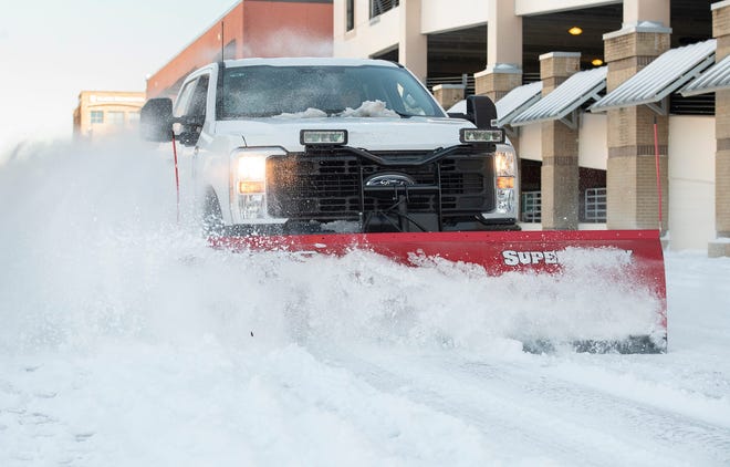 Garrett Foshee and Austin Smith, of Alabama, plow a road with Roads Inc. in downtown Pensacola a day after a record snowfall in the Florida coastal city on Wednesday, Jan. 22, 2025.