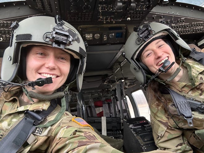 Capt. Rebecca Lobach and Chief Warrant Officer 2 Sabrina Bell smile in the cockpit of a UH-60 Black Hawk helicopter, the model of helicopter Lobach was flying in during the crash, on Feb. 28, 2024.