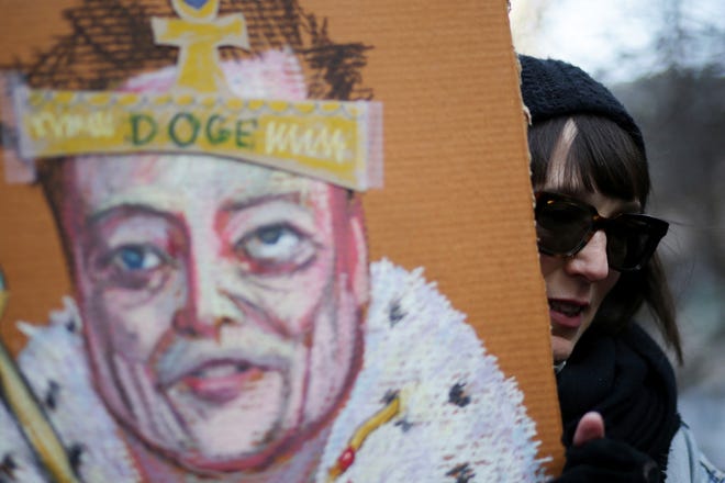 A protester holds a sign with an image of Elon Musk during a rally in New York City against the Trump administration on Feb. 5, 2025.