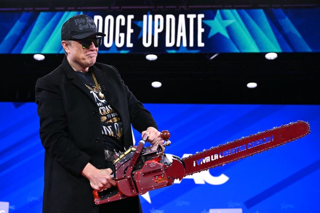 Elon Musk holds a chainsaw during the annual Conservative Political Action Conference (CPAC) at the Gaylord National Resort & Convention Center at the National Harbor in Oxon Hill, Md., on Feb. 20, 2025.