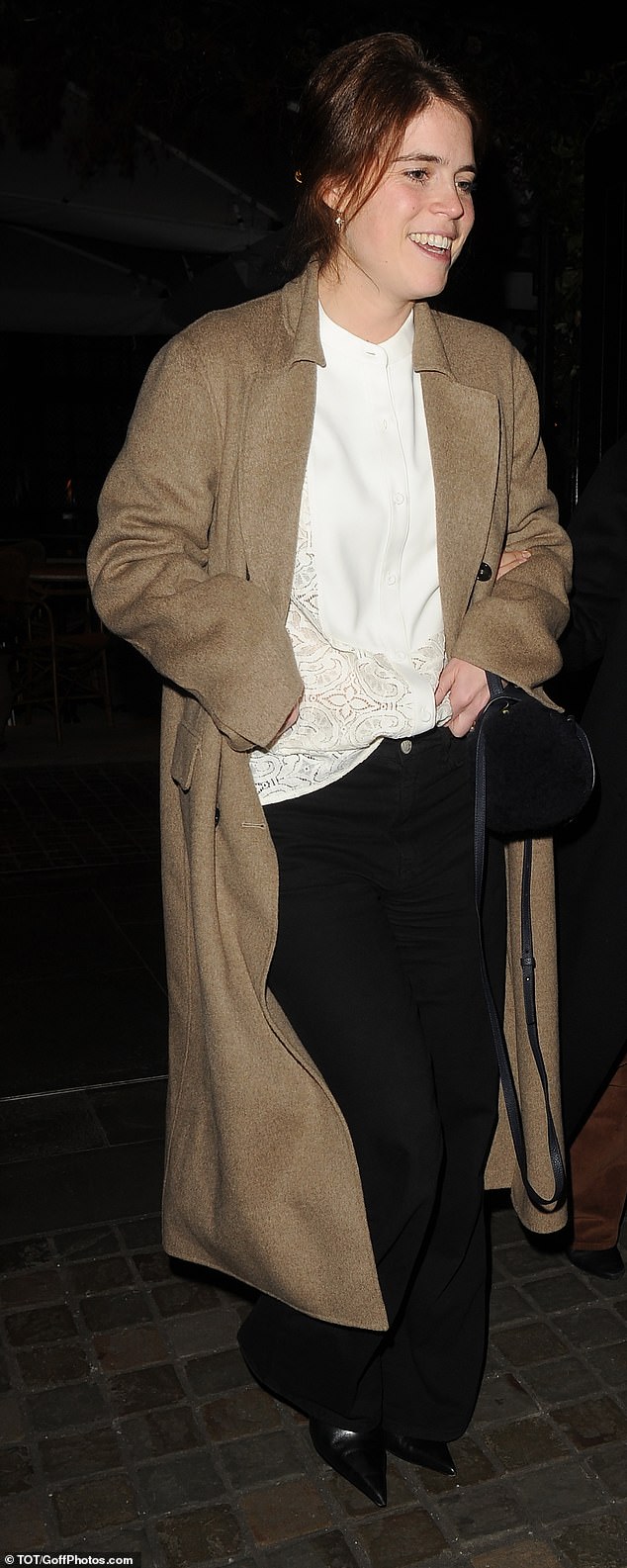 Eugenie donned a tan-coloured overcoat along with a white button-up blouse that had intricate lace detailing along the hem