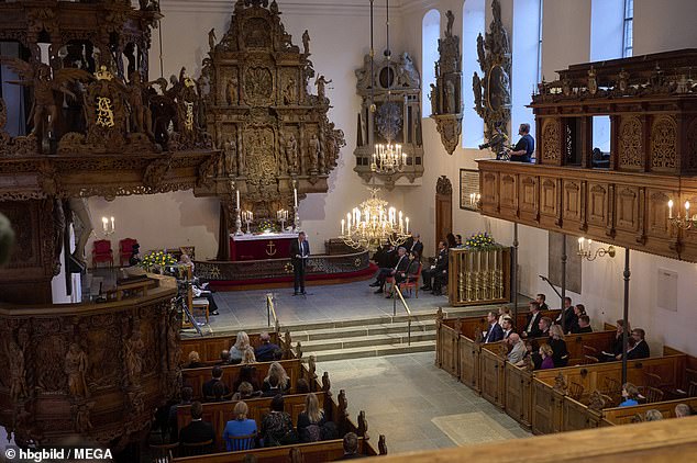 The other members of the congregation were seated on wooden pews in the ornate church