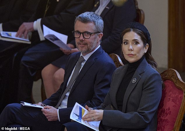 The Danish royal couple were pictured with the order of service, illustrated in the blue and yellow of the Ukrainian flag