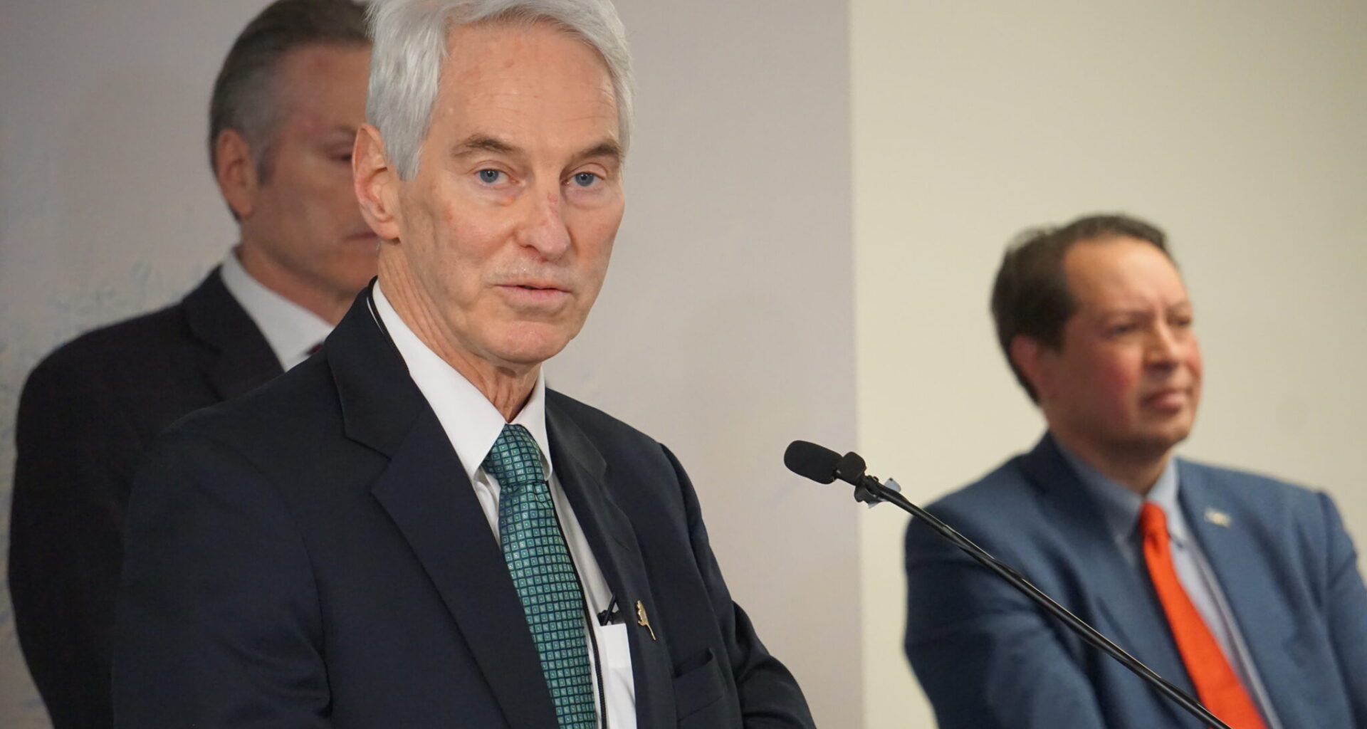 Frank Richards, president of the Alaska Gasline Development Corp., speaks at a Jan. 6, 2025, news conference held in Anchorage by Gov. Mike Dunleavy. Dunleavy and Randy Ruaro, executive director of the Alaska Industrial Development and Export Authority, are standing behind RIchards. (Photo by Yereth Rosen/Alaska Beacon)