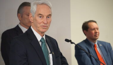 Frank Richards, president of the Alaska Gasline Development Corp., speaks at a Jan. 6, 2025, news conference held in Anchorage by Gov. Mike Dunleavy. Dunleavy and Randy Ruaro, executive director of the Alaska Industrial Development and Export Authority, are standing behind RIchards. (Photo by Yereth Rosen/Alaska Beacon)