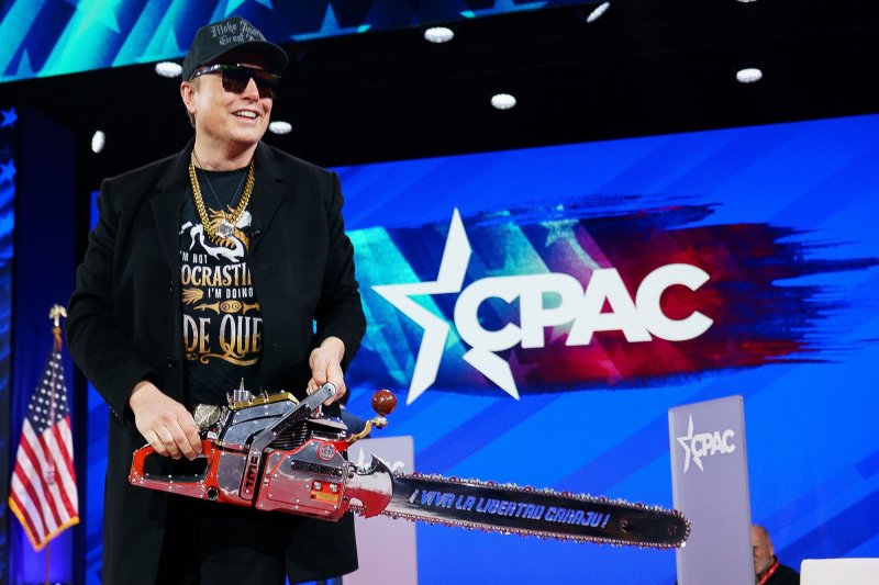 Entrepreneur and U.S. special government employee Elon Musk holds a chainsaw at the Conservative Political Action Conference 2025 at National Harbor, Md., on Thursday and on Saturday cautioned all federal employees to account for their prior week's work. Photo by Will Oliver/UPI