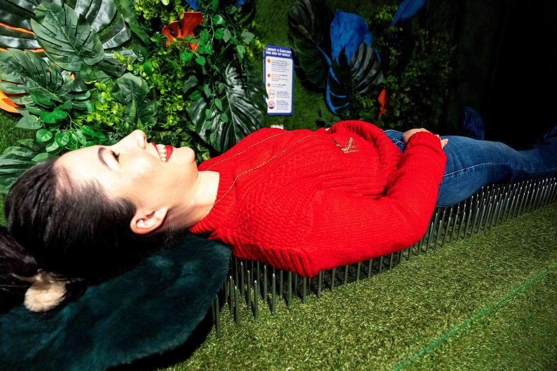 A woman lays on the "Bed of nails" as she visits the HaHaHouse museum of laughter in central Zagreb, on January 21, 2025. The 450-square-metre (4,844-square-feet) museum, which opened in January, offers eight interactive zones and has also an educational part featuring the history of humour from ancient to modern times and via different formats -- theatre, film or Internet. (Photo by Damir SENCAR / AFP)
