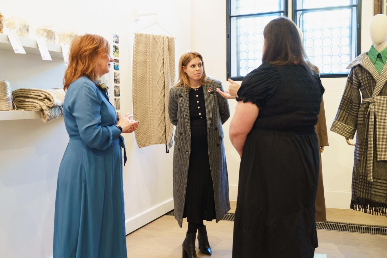 three women engaged in conversation in a fashion display area