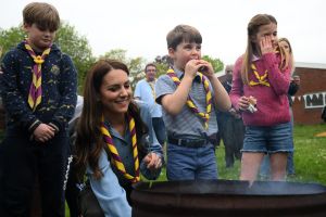 Britain's Princess Charlotte of Wales (R) wipes her eyes as she and her brother Britain's Prince Louis of Wales (C) eat marshmallow biscuits as they take part in the Big Help Out, during a visit to the 3rd Upton Scouts Hut in Slough, west of London on May 8, 2023, where the family joined volunteers helping to renovate and improve the building. People across Britain were on Monday asked to do their duty as the celebrations for King Charles III's coronation drew to a close with a massive volunteering drive. (Photo by Daniel LEAL / POOL / AFP) (Photo by DANIEL LEAL/POOL/AFP via Getty Images)