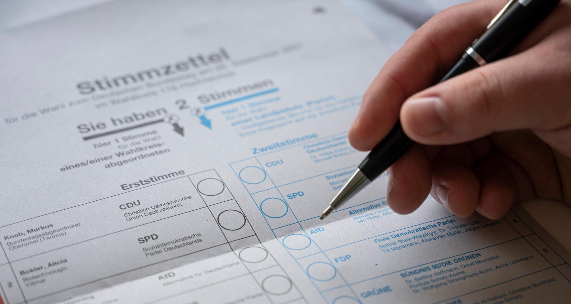 Nahaufnahme eines Stimmzettels und Briefwahlunterlagen.