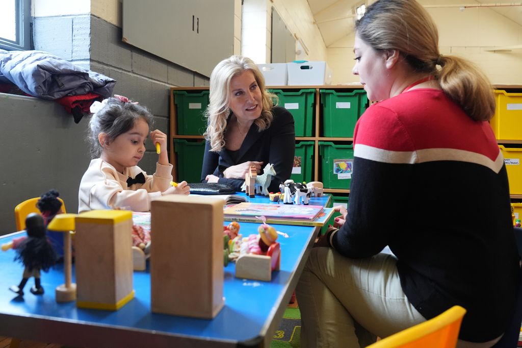 Duchess Sophie with blonde curled hair at a table with a little girl