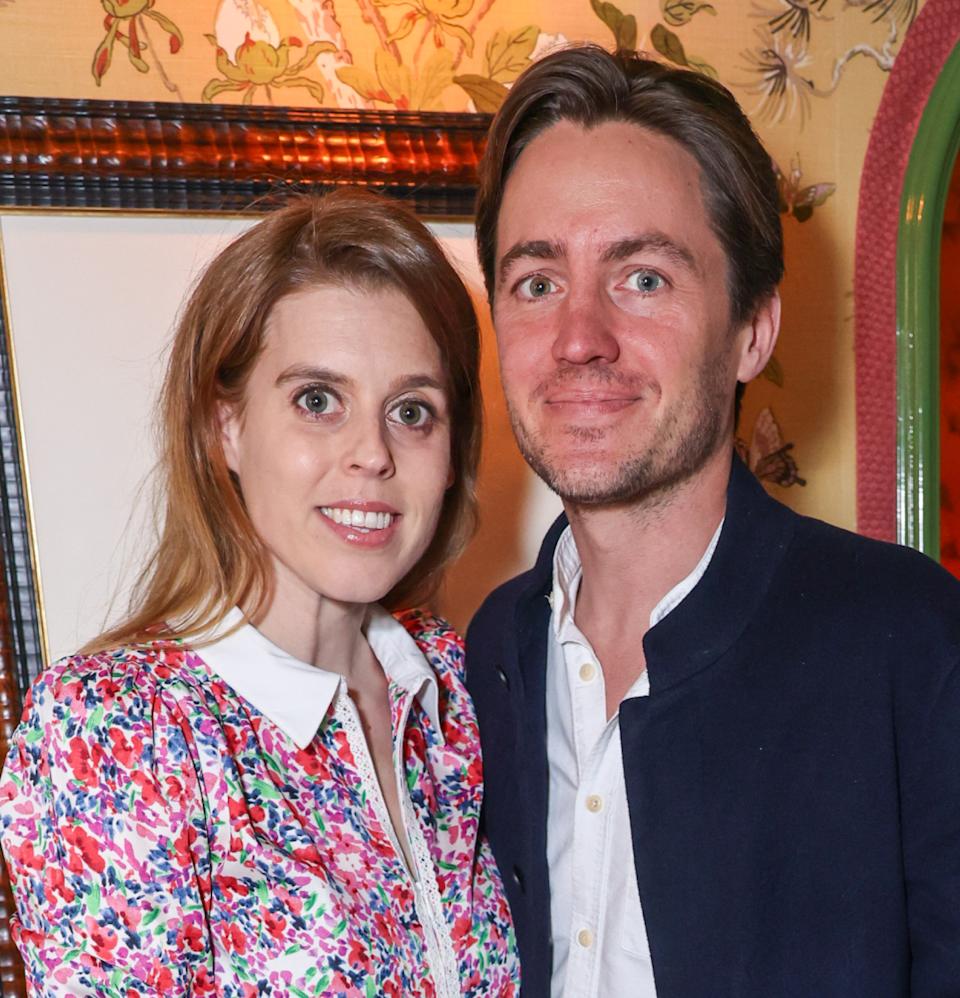  Princess Beatrice wearing a floral dress smiling and standing next to Edoardo Mapelli Mozzi . 