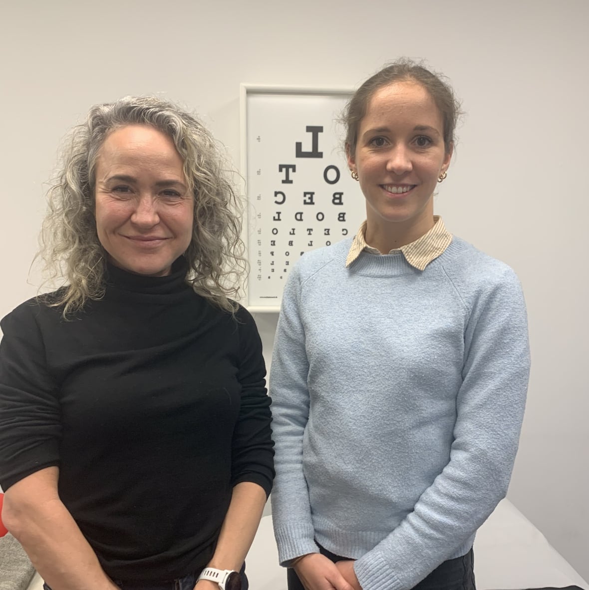 Two women standing in a doctor's office.