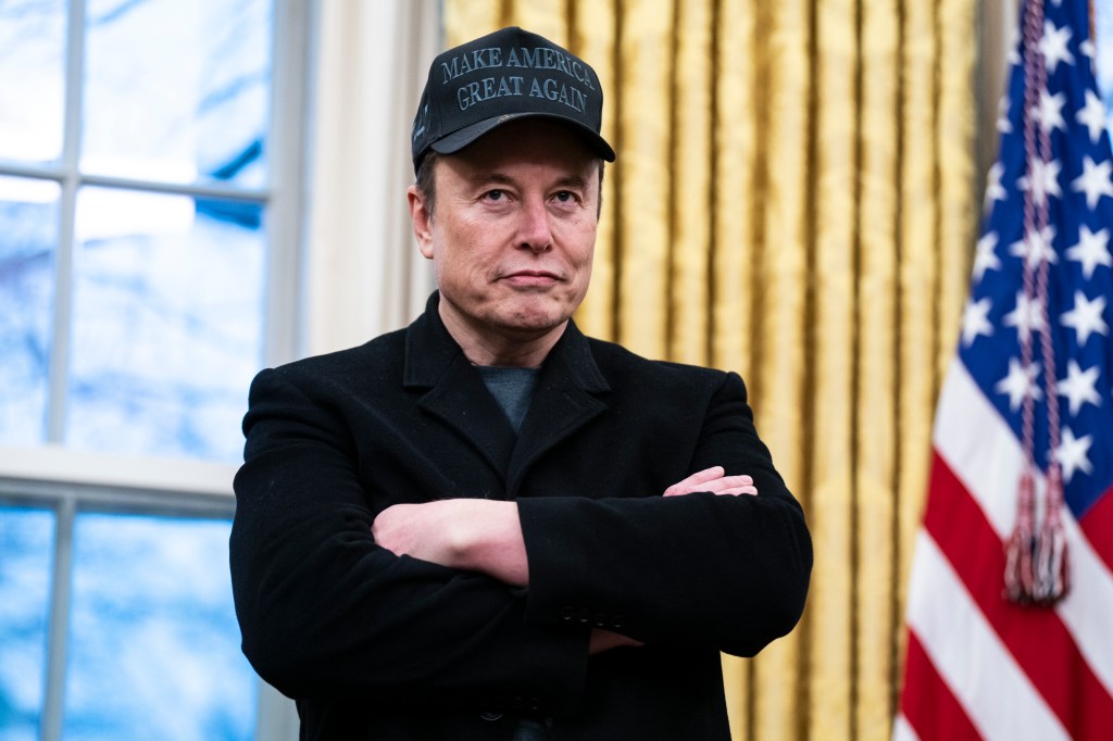 Elon Musk in a black jacket, speaking with President Donald J Trump and reporters in the Oval Office at the White House in February 2025