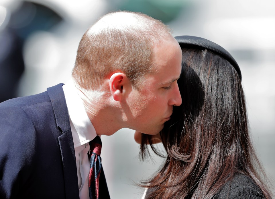 Prince William kissing Meghan Markle on the cheek.