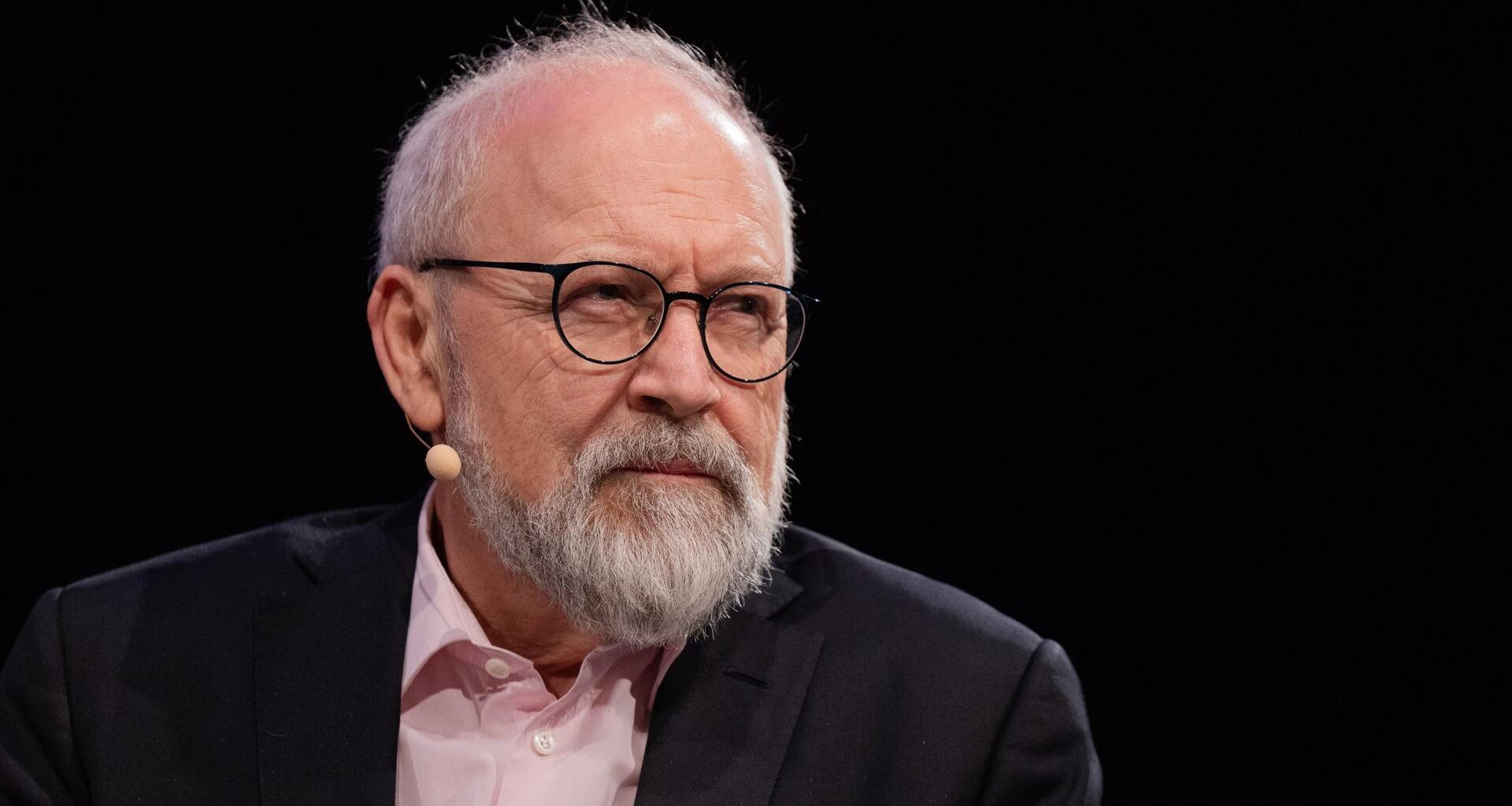 Herfried Münkler sitzt im Rahmen des Literaturfestivals Lit.Cologne auf einer Bühne und schaut mit kritischem Gesichtsausdruck an der Kamera vorbei.