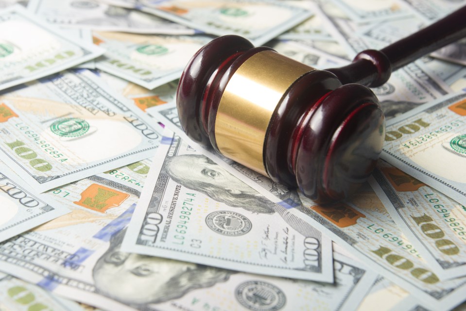 Gavel on top of one hundred dollar bills.