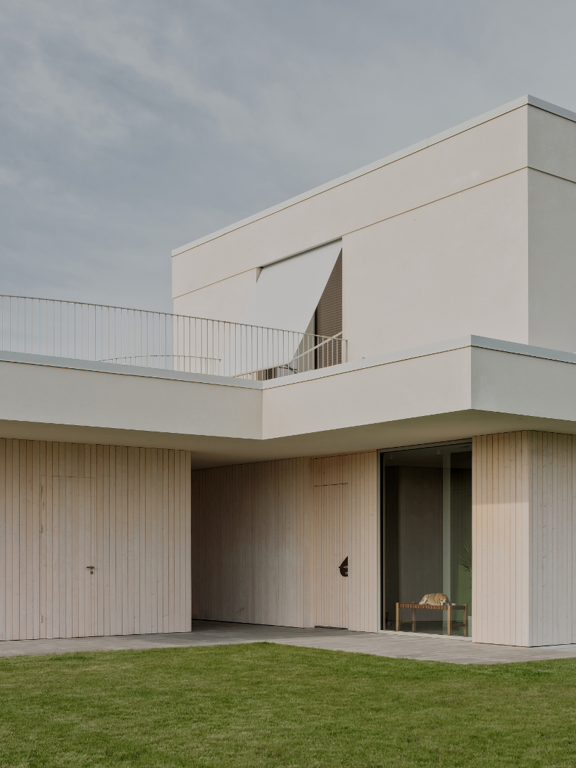 GAISS rests house's linear symmetrical volume on timber-clad plinth in latvia