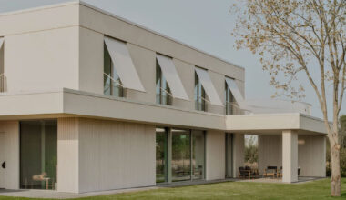 GAISS rests house's linear volume on timber-clad plinth in latvia