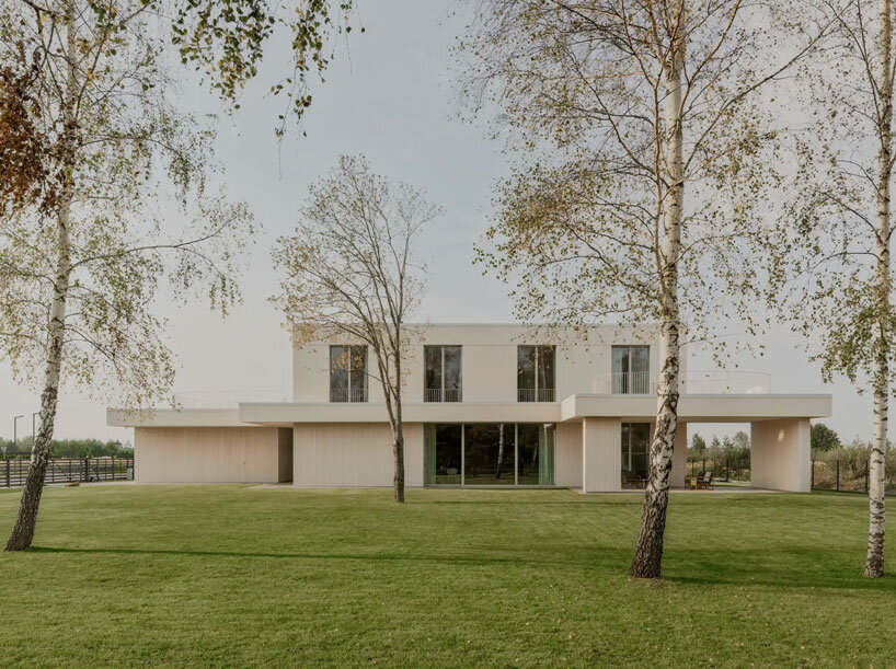 GAISS rests house's linear symmetrical volume on timber-clad plinth in latvia
